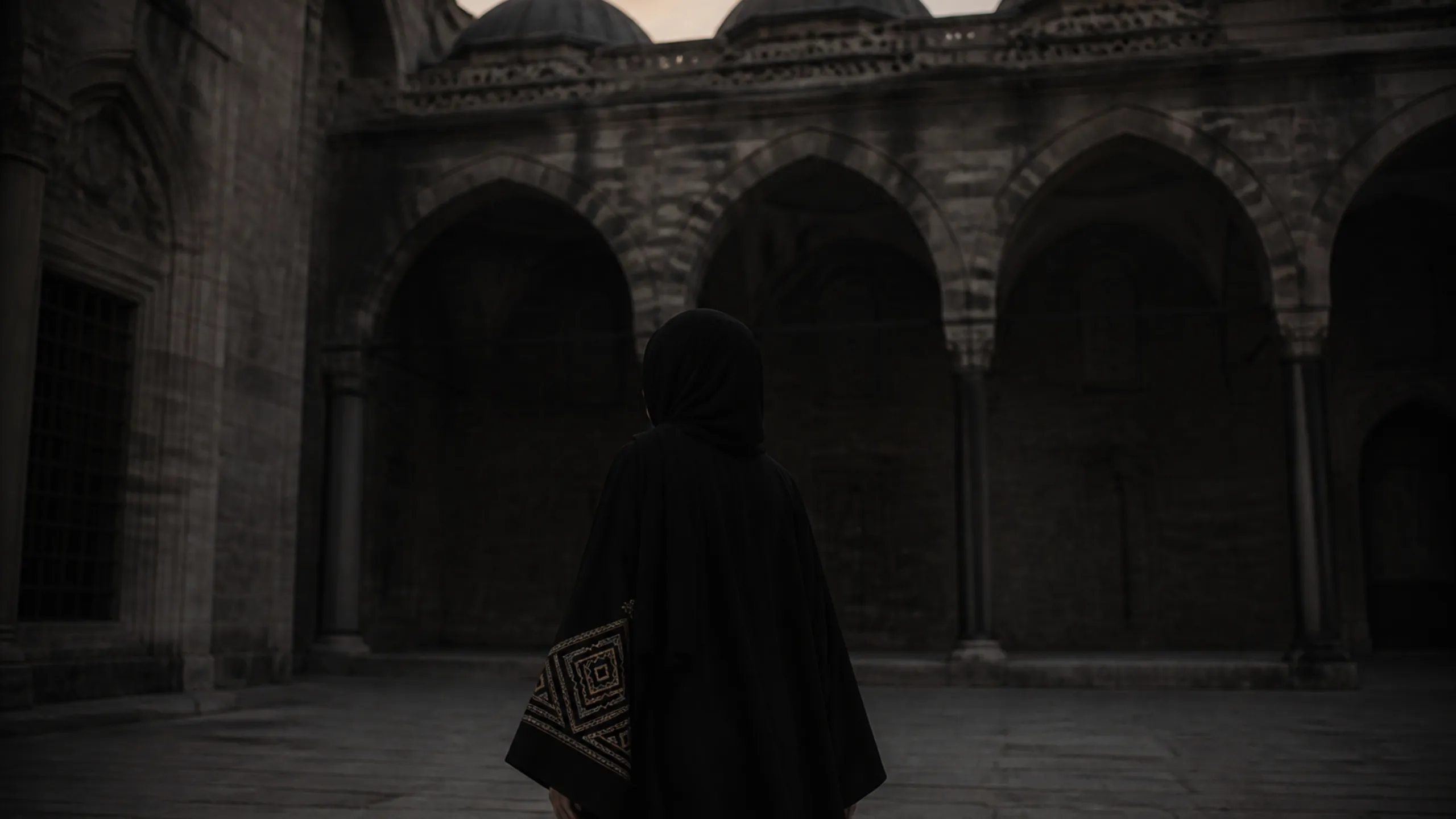 Siyah ferace giymiş kadın, İstanbul taş avlusunda, arkadan